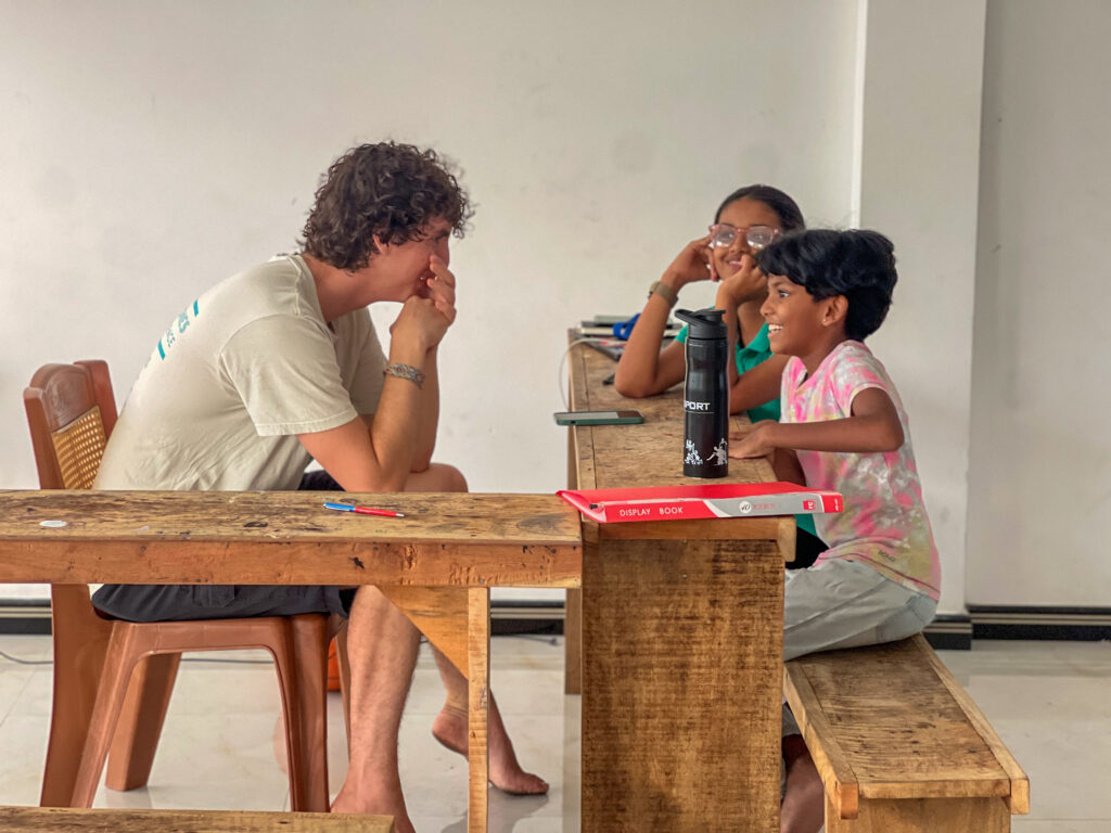 A volunteers laughing with his students