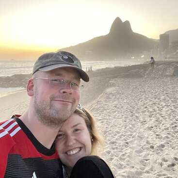 A couple posing at the beach in front of mountain