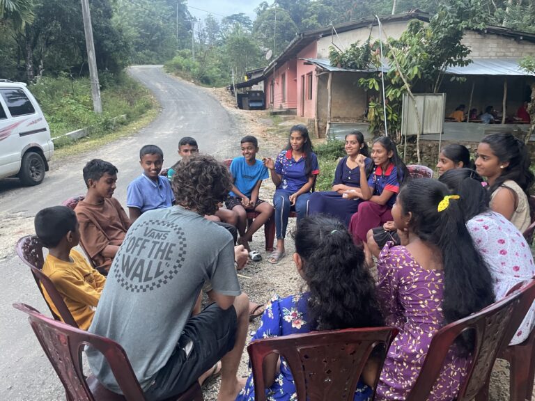 Students sitting in a circle outside